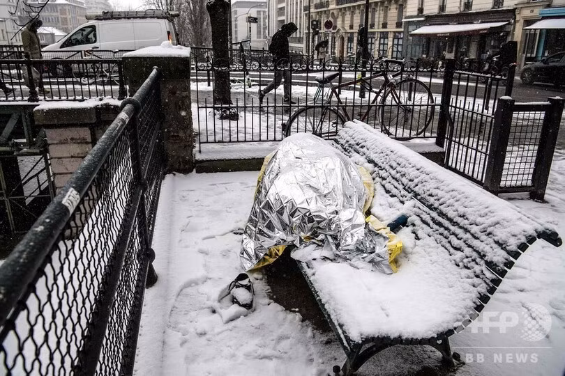 Trời tuyết tại Paris, một mặt là khung cảnh tuyệt đẹp cho du khách và những người yêu thích một khung cảnh lãng mạn, lại là ác mộng với người vô gia cư. Một thống kê vào tháng 2/2018 cho thấy có 3.000 người vô gia cư sống trên các đường phố Paris. Trong ảnh, một người đàn ông vô gia cư phủ chăn ngủ trên băng ghế giữa trời tuyết ở Paris. Cơ quan thời tiết của Pháp đã đưa ra cảnh báo màu cam, mức cao thứ hai, và cho biết tuyết sẽ còn rơi nhiều hơn vào tối 23/1.