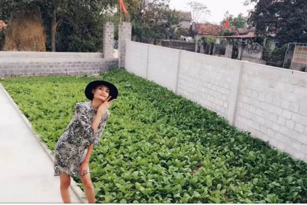 Người mẫu Lê Thúy hào hứng chụp ảnh bên vườn rau xanh mướt tại quê nhà Quảng Bình.