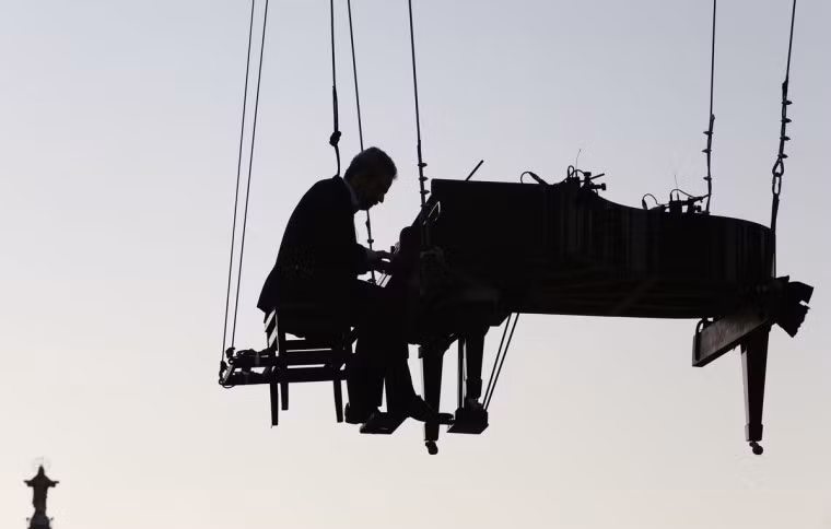Mặc dù màn biểu diễn có chứa yếu tố rủi ro nhưng đây không phải là lần đầu tiên Ricardo de Castro Monteiro thực hiện.. Trước đây, người nghệ sĩ sáng tạo này cũng đã treo mình ở một số địa điểm khác nhau để thể nghiệm cảm giác chơi nhạc giữa không gian rộng lớn, thoáng đãng.