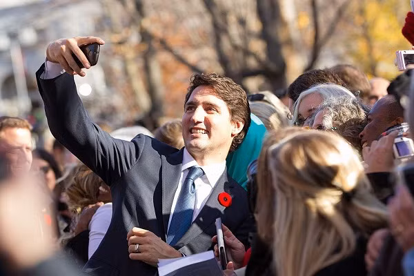 Ông dùng điện thoại selfie cùng người dân Canada vào năm 2017.