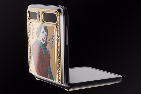Smartphone màn hình gập Galaxy Z Flip phiên bản Joker và Harley Quinn được khoác trên mình lớp vỏ mạ vàng rất sang trọng. Ở hai mặt lưng của phần gập là hình ảnh đầy màu sắc của hai nhân vật nổi tiếng. Ảnh: Caviar