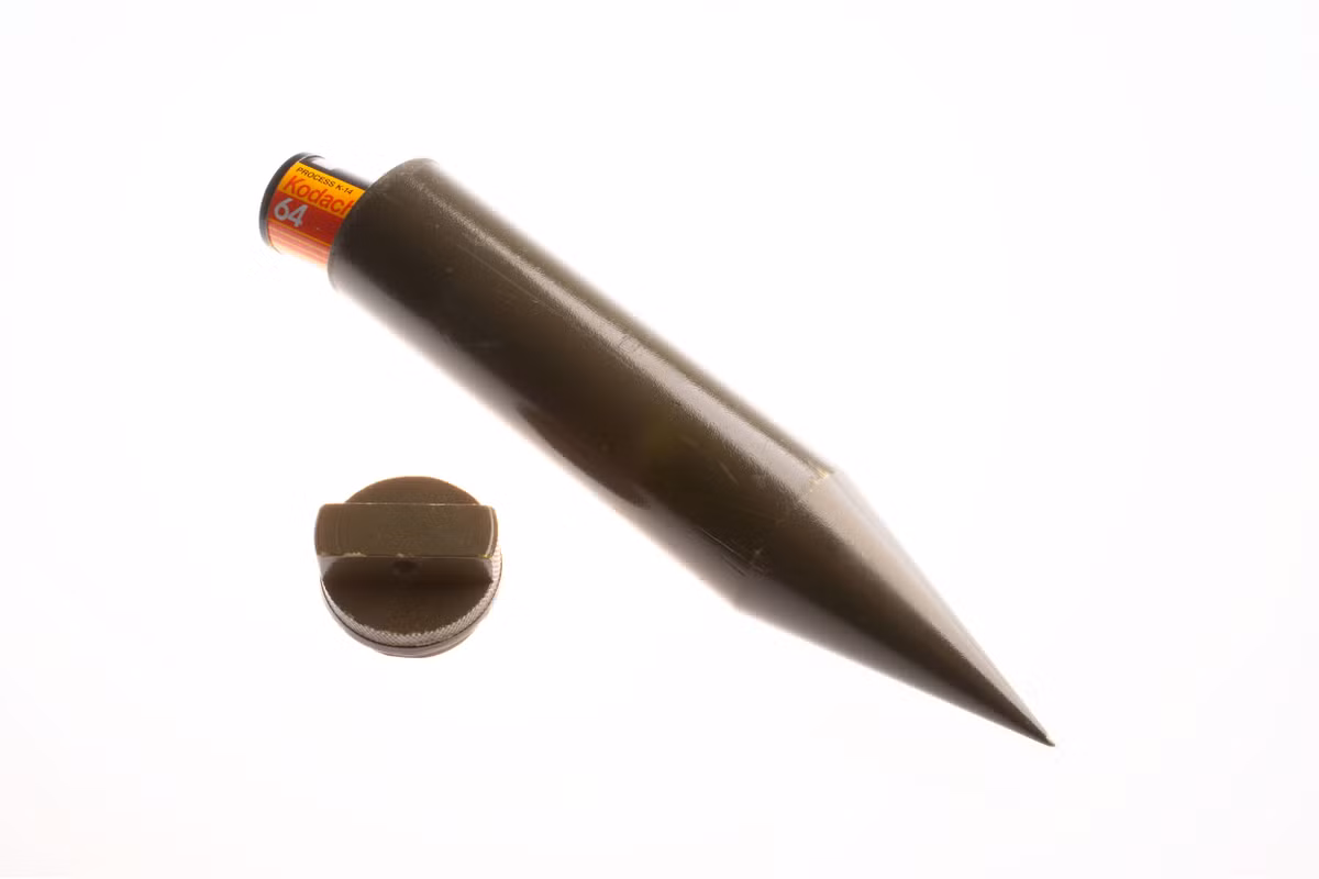 "Dead-drop" là thuật ngữ được sử dụng trong tình báo, ám chỉ một vật bí mật để 2 người gởi tài liệu cho nhau mà không cần phải gặp mặt. Cách giải quyết là truyền thông điệp thông qua "dead-drop" tại địa điểm nào đó được định sẵn. Ở đây là một đầu nhọn rỗng bên trong, vật nhọn này có thể được cắm xuống đất, lưu giữ tin nhắn, tài liệu hay một thước phim bên trong.