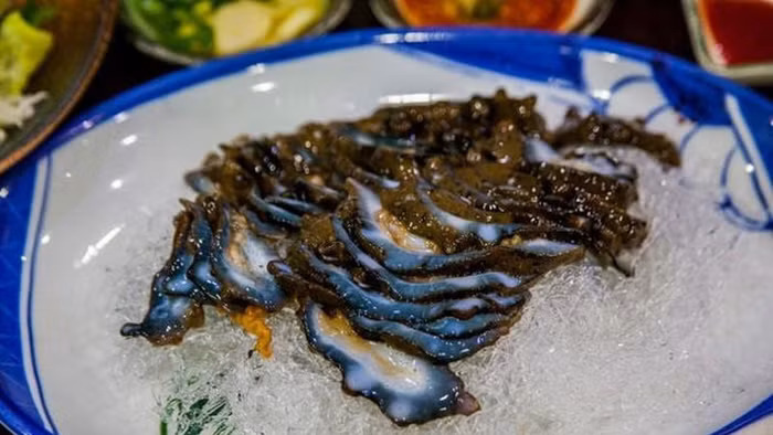 Địa điểm lý tưởng để thưởng thức sản vật này là hòn đảo du lịch Jeju. Sau khi ngâm muối 30 phút, hải sâm được làm sạch nội tạng, thái phần thịt thành từng miếng nhỏ vừa ăn và bày lên đĩa. Món ăn sống kích thích vị giác mang đến trải nghiệm ẩm thực hấp dẫn.