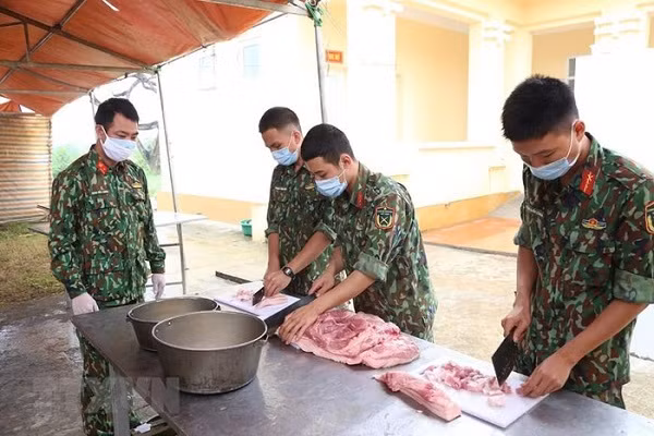 Các chiến sỹ Trung đoàn 58, Sư đoàn 308 (Quân đoàn 1) chuẩn bị lương thực, thực phẩm chăm lo bữa ăn cho người thực hiện cách ly tập trung tại đơn vị. (Ảnh: Dương Giang/TTXVN)