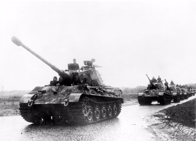 Đó chính là xe tăng Tiger II – cỗ xe tăng có trọng lượng nặng nhất trong Chiến tranh Thế giới thứ 2. Nó có rất nhiều tên gọi khác, ví dụ như định danh chính thức là Panzerkampfwagen Tiger Ausf. B gọi tắt là Tiger B, định danh lưu trữ là Sd.Kfz. 182, trong khi người Mỹ gọi nó là King Tiger (vua cọp) còn người Anh gọi là Royal Tiger. Thế nhưng, cái tên Tiger II vẫn là phổ biến nhất. Nó là sự tiếp nối của dòng tăng Tiger I nhưng có giáp tốt hơn hẳn.