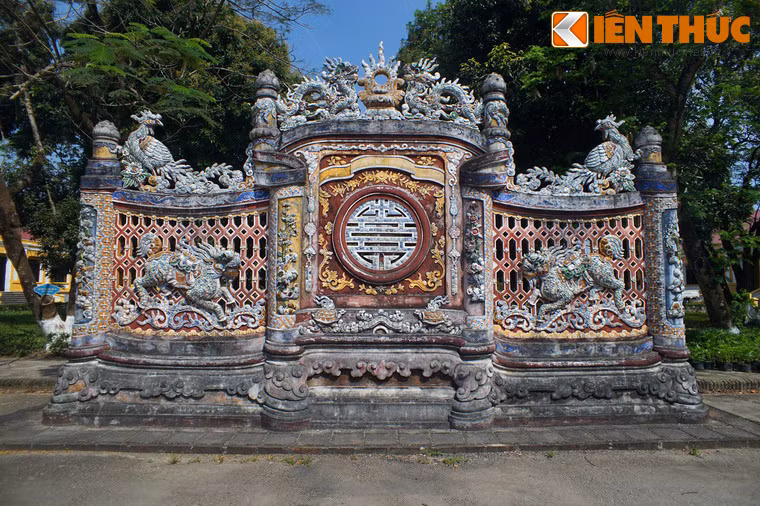 Sau cổng là bức bình phong xây kiểu kiểu cuốn thư, trang trí tứ linh, chữ thọ và các biểu tượng truyền thống vô cùng tỉ mỉ, công phu, màu sắc lộng lẫy. Công trình này từng bị phá hủy, được phục dựng vào năm 2010.