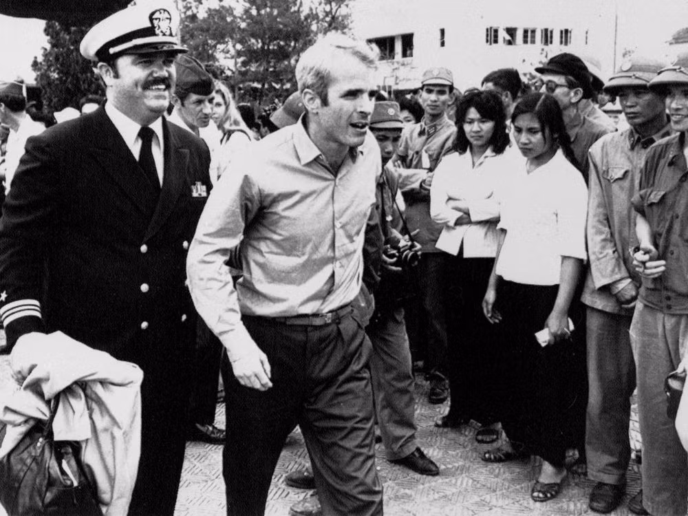 John McCain được hộ tống bởi Trung úy, nhân viên quan hệ công chúng Jay Coupe Jr hộ tống ở sân bay Gia Lâm, Hà Nội trong chương trình trao đổi tù binh chiến tranh sau Hiệp định Paris, tháng 3/1973. Ảnh: Vintag.