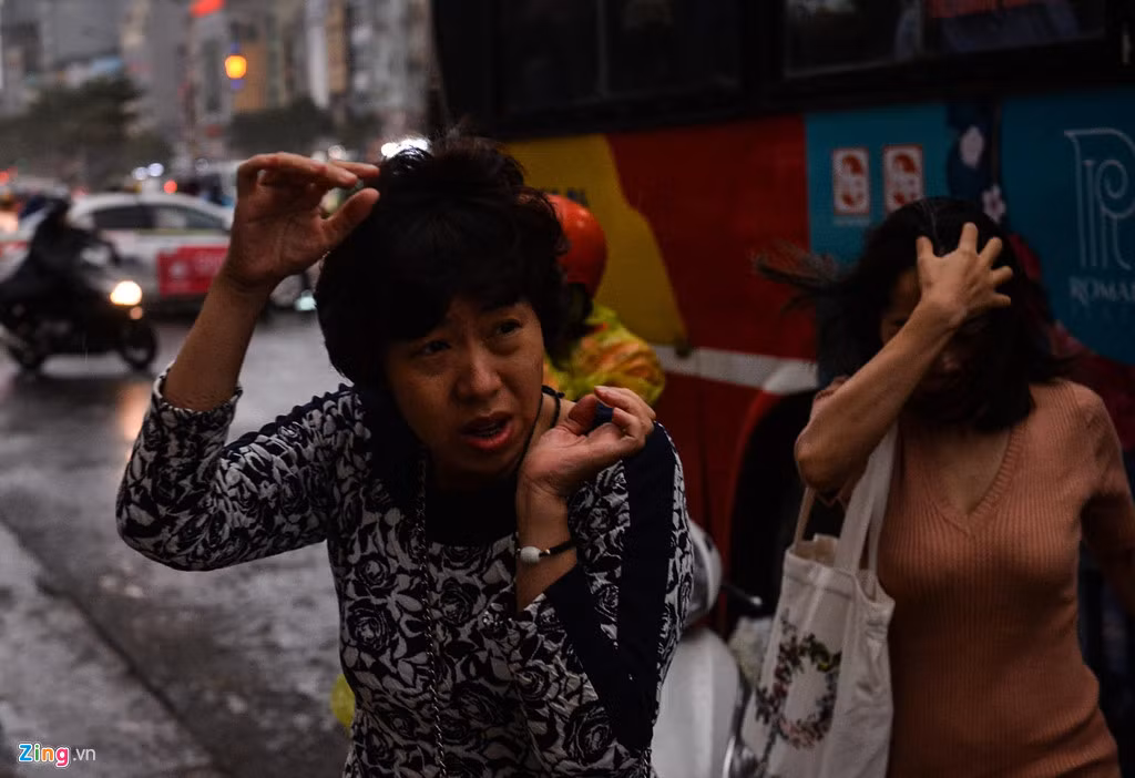 Những người vừa xuống xe buýt bất ngờ vì cơn mưa kéo đến quá nhanh.