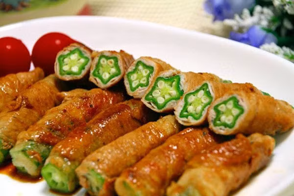 Váng đậu cuộn đậu bắp sốt chua ngọt: Đậu bắp ngâm muối, rửa sạch. Váng đậu ngâm nở mềm, trải váng đậu ra, cho đậu bắp vào, cuộn tròn như cuộn nem, dùng tăm cố định. Bắc chảo lên bếp, chiên sơ qua cho váng đậu vàng rồi vớt ra.
