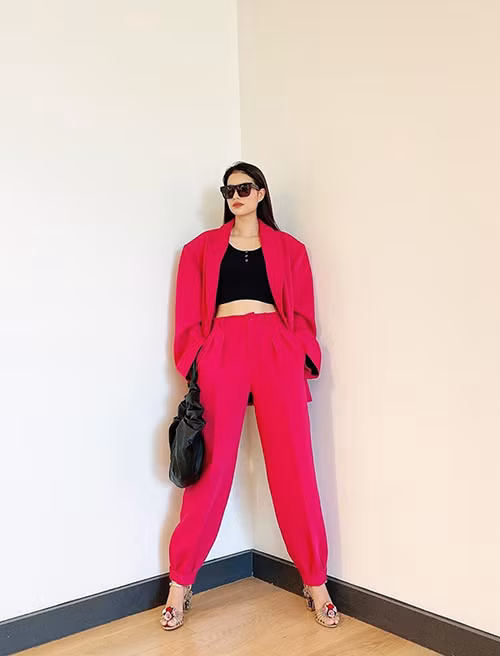 Hoa hậu Phạm Hương trông cực nổi bật với cách mix suit hồng cánh sen đi cùng áo ctop-top đen.