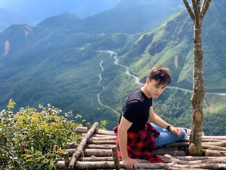 Áo phông mix với jean rách gối và buộc áo sơ mi kẻ làm điểm nhấn cho set đồ năng động.