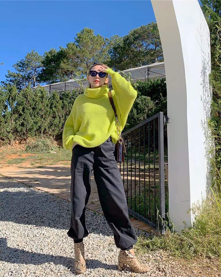 Chiếc áo sweater cổ lọ màu xanh neon được Tóc Tiên chưng diện trong set đồ theo phong cách đường phố.