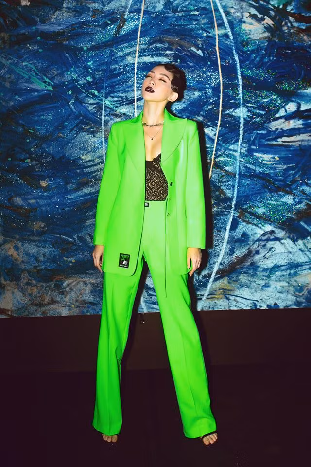 Lần khác, giọng ca 8X cực sành điệu khi mix áo corset đen mặc bên trong với suit xanh neon bên ngoài cùng cách makeup đậm và làm tóc cổ điển.