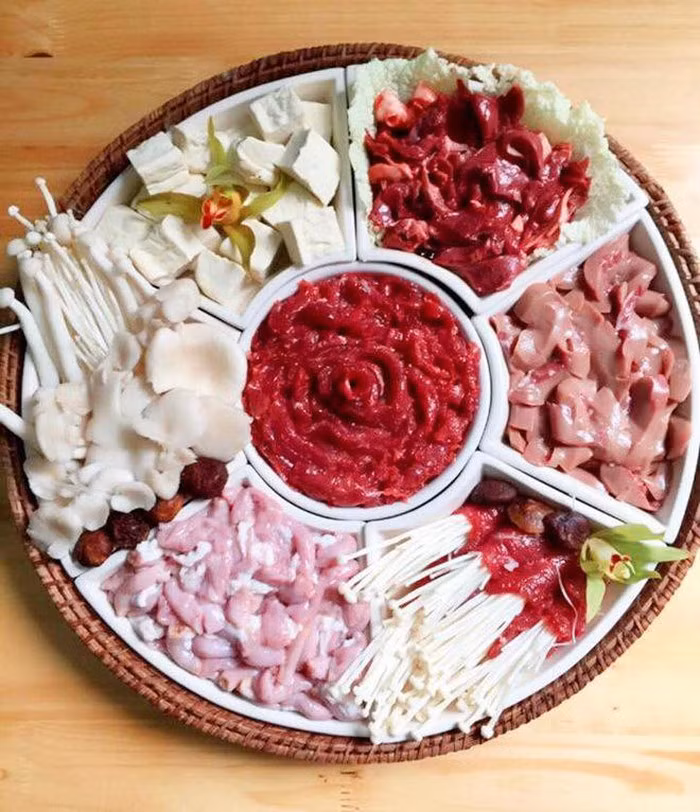 Trong lúc chờ ninh nước dùng, chúng ta xếp tất cả các đồ ăn lên bàn, nồi lẩu để ở giữa. Ninh xương được khoảng 30 phút thì cho ngô ngọt thái lát vào ninh cùng xương. Ninh đến khi nước dùng ngọt như ý, xương mềm thì nêm bột nêm vào và đổ ra nồi nấu lẩu.