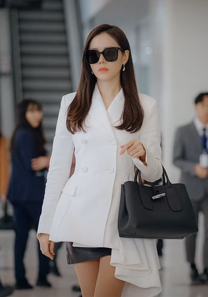Nếu chưa có ý tưởng gì diện đồ cho mai, các nàng có thể tham khảo set đồ với áo blazer trắng và chân váy da màu đen sành điệu.