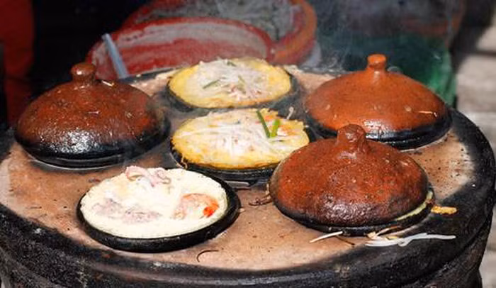 Bánh xèo: với những nơi khác, bánh xèo Ninh Thuận được đổ trong những chiếc khuôn làm bằng đất nung, đặt trong chiếc lò tròn (khoảng 4 – 5 khuôn). Bánh không cần nhiều dầu để tráng khuôn, lượng bột vừa đủ dày để tạo ra độ giòn mà không mất độ dẻo của bánh. Khi ăn, thêm ít giá tươi. Ảnh: Dulich24.