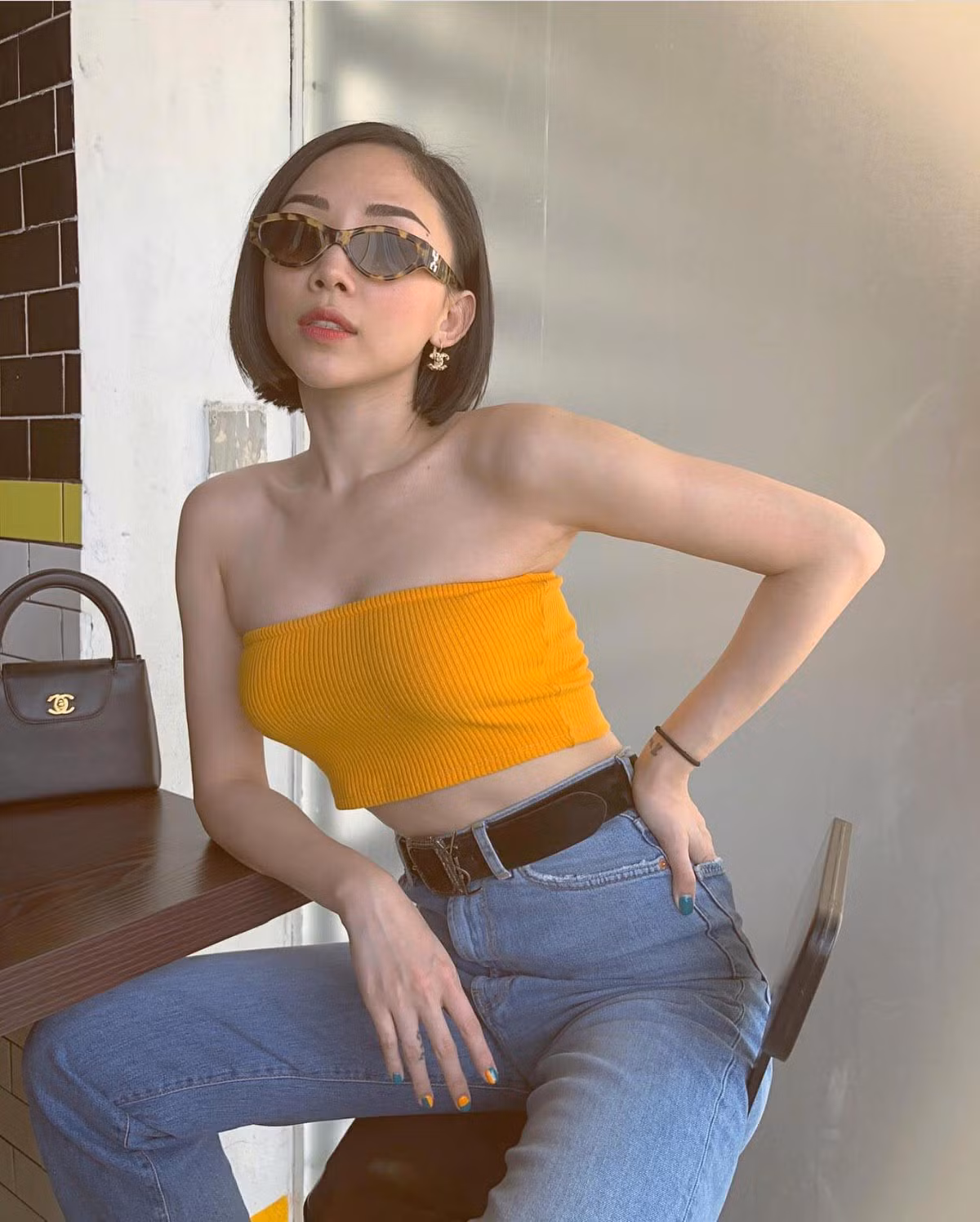 Nữ ca sĩ Tóc Tiên diện chiếc áo quây màu vàng hot trend cùng với quần jeans dáng rộng với điểm nhấn là chiếc thắt lưng to bản.