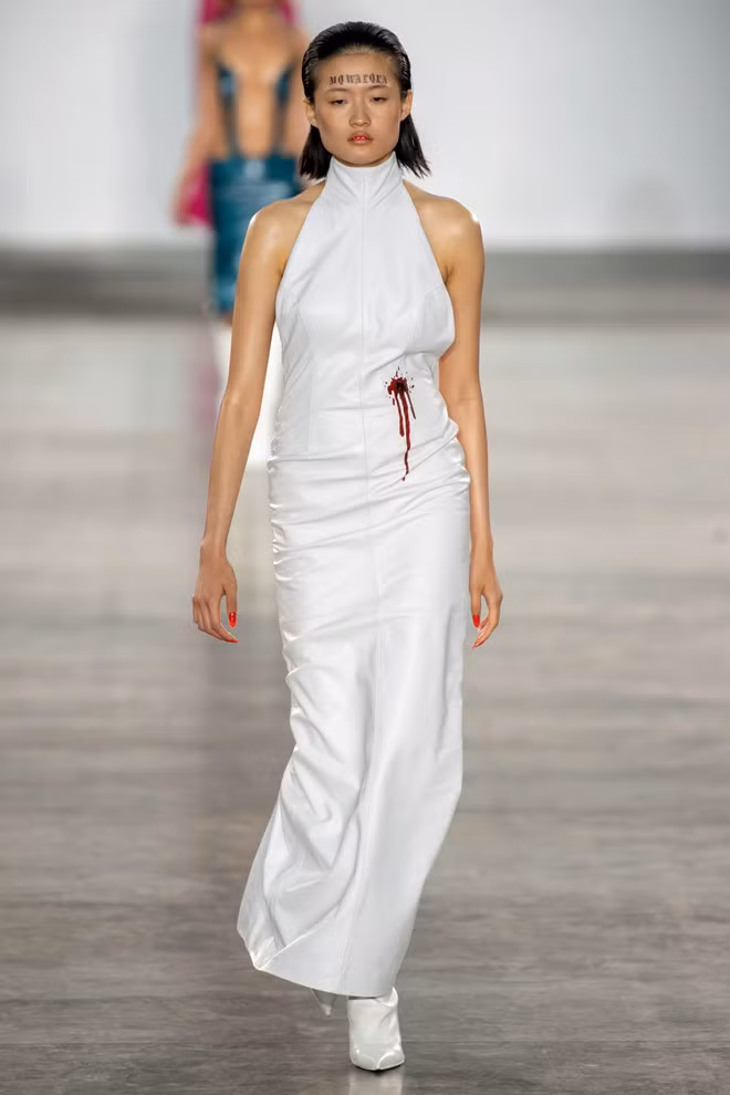 Cảm hứng trong BST của nhà mốt Fashion East đến từ sự phức tạp và nỗi đau giằng xé trong tình yêu. Điều này thể hiện qua những bộ suit và đầm cổ yếm sắc trắng với họa tiết vết thương rỉ máu.