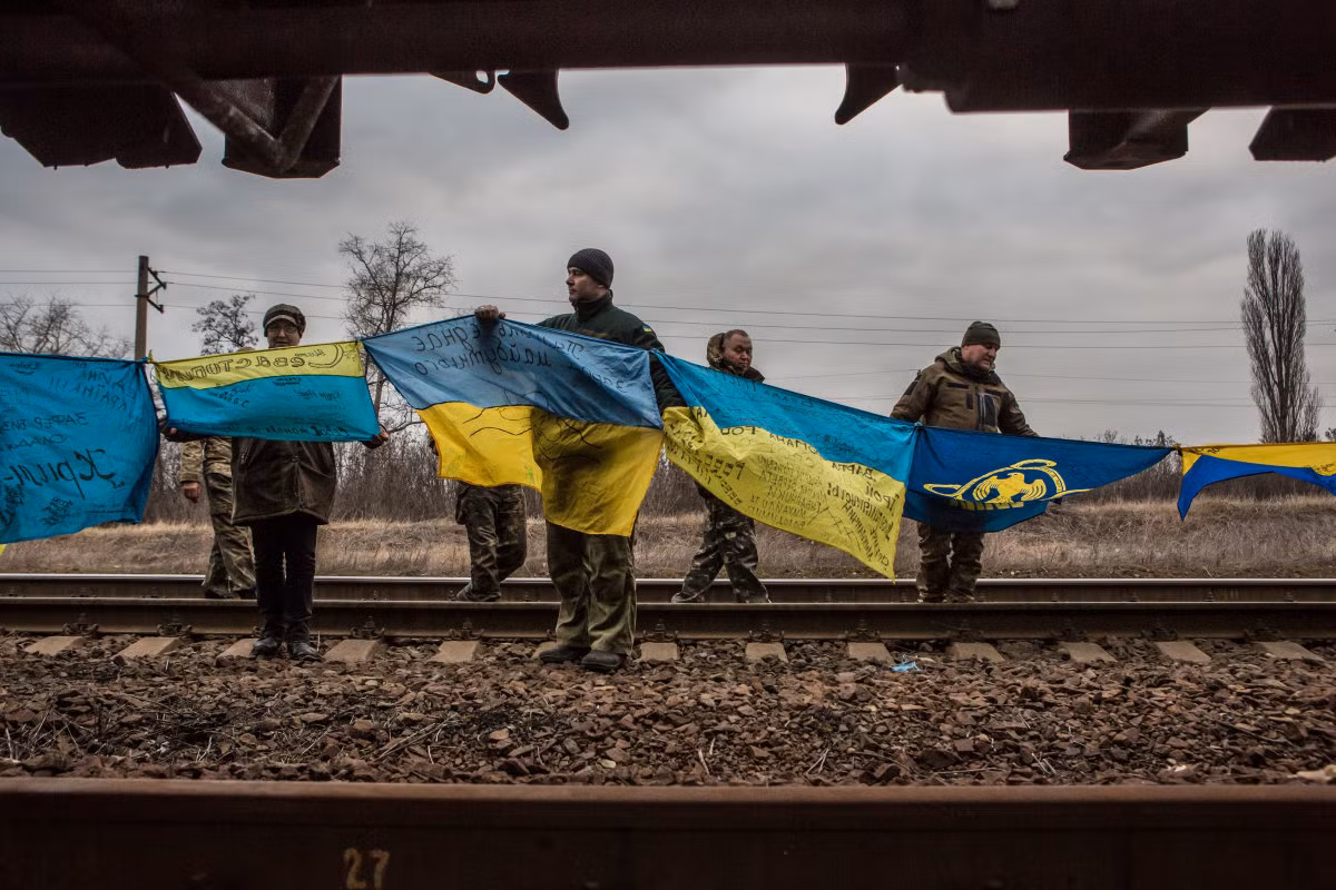 Các nhà hoạt động giơ cờ Ukraine khỏi đoàn tàu chở than bị chặn lại ở nhà ga Kryvyi Torets thuộc làng Shcherbynivka. Ảnh USN
