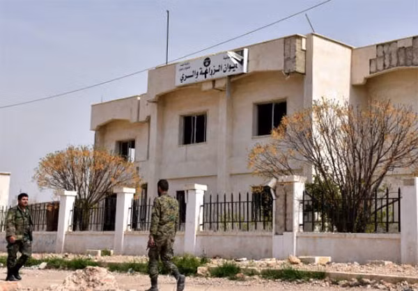 Hai người lính Syria tuần tra trước một tòa nhà. Ảnh FNA