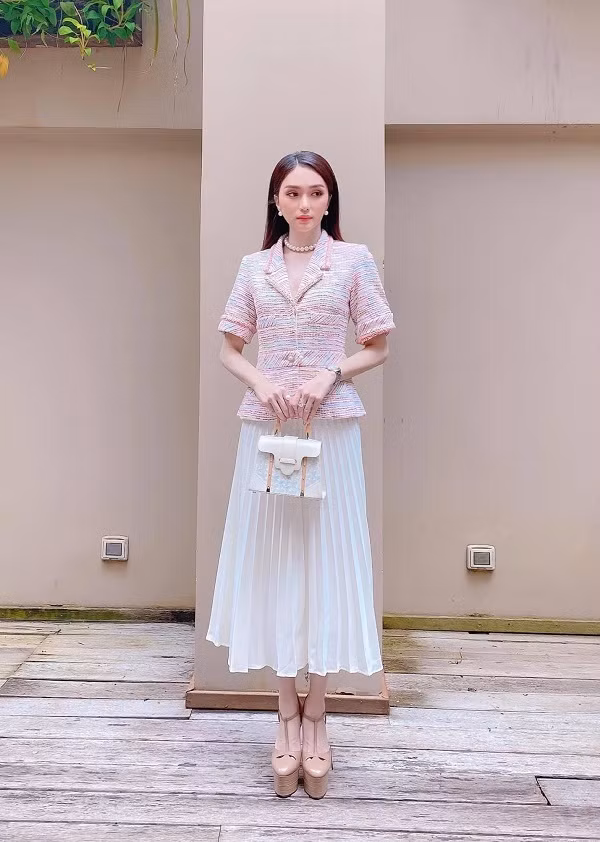 Hương Giang với phong cách tiểu thư cổ điển khi kết hợp váy dập ly và túi xách thanh lịch.
