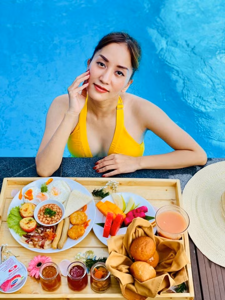 Khánh Thi ăn sáng sang chảnh ở bể bơi. Cô viết: "Yêu và được yêu là một bản nhạc nghe mãi không chán".