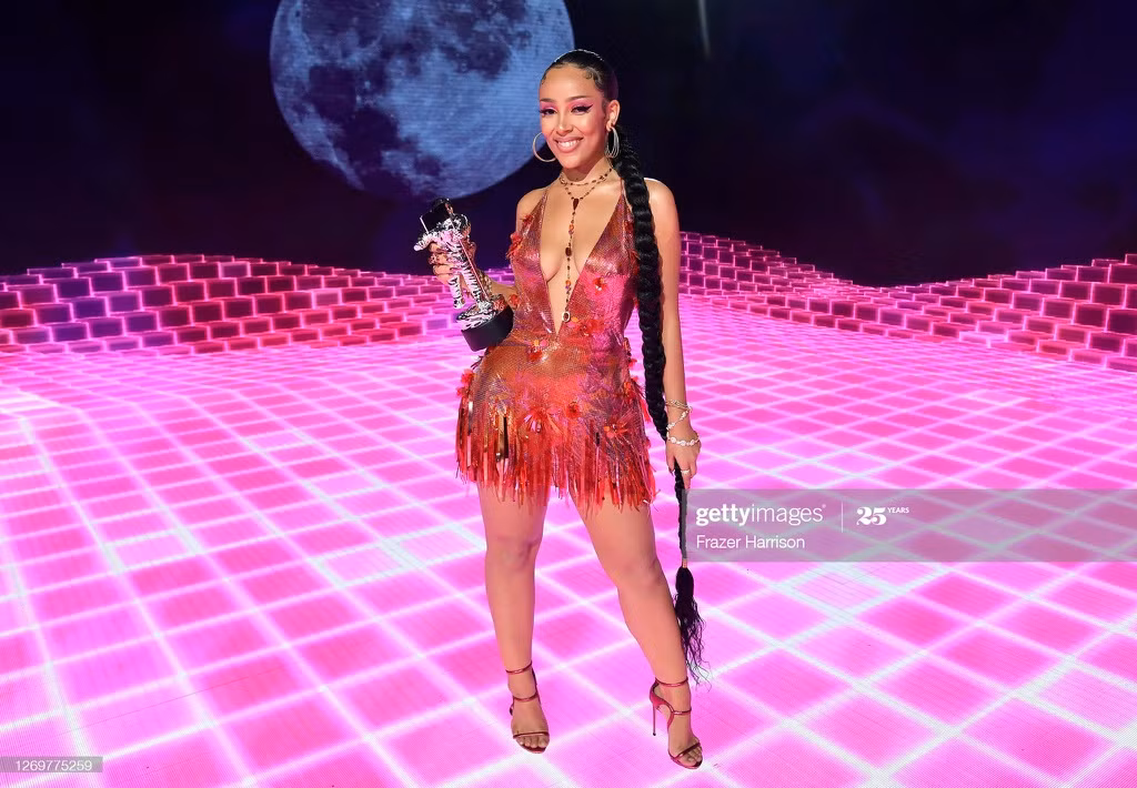 Ngay sau màn trình diễn Say So và Like That, Doja Cat nhanh chóng thay bộ catsuit sặc sỡ thành váy xẻ ngực gợi cảm để trở lại sân khấu nhận giải. Cô đánh bại nhiều đối thủ nặng ký ở hạng mục Nghệ sĩ mới xuất sắc tại VMAs 2020. Ảnh: Getty.