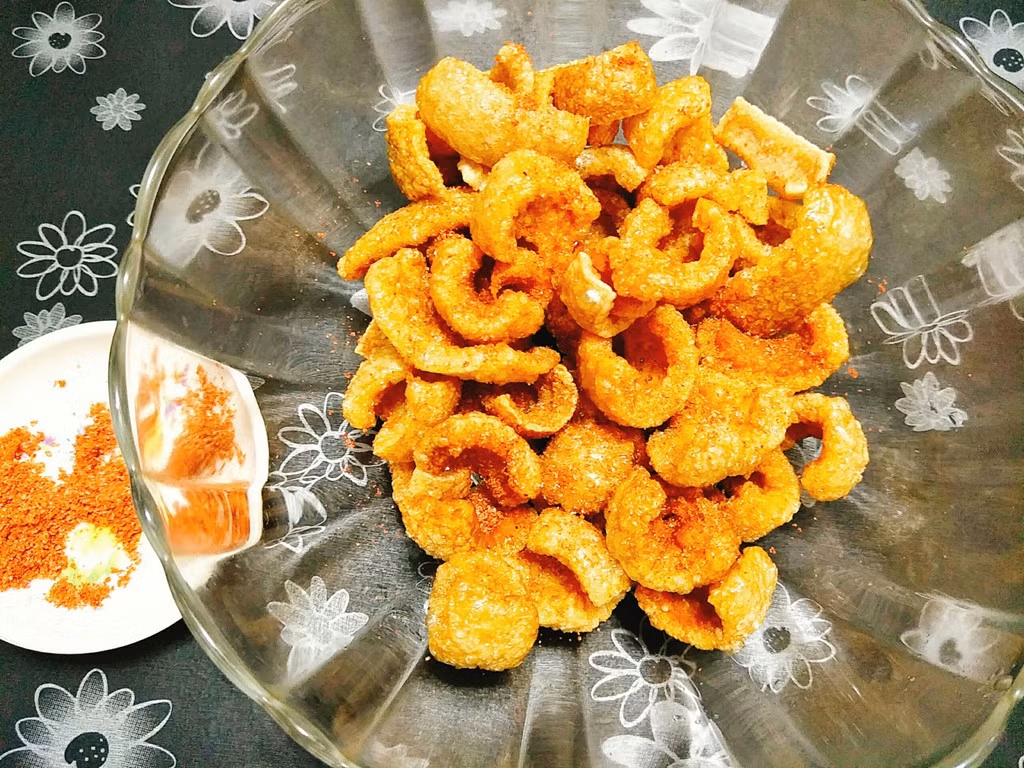 Cho muối, bột ớt, tiêu vào bát rồi trộn đều. Bạn đổ bì chiên giòn vào bát to hoặc túi zip sau đó rắc hỗn hợp muối ớt cho vừa đủ, xóc đều để bì chiên giòn bám đều gia vị rồi cho ra đĩa thưởng thức.