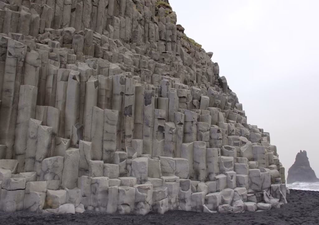 Bãi biển cát màu đen Reynisfjara: Nằm gần thị trấn Vik, trên bờ biển phía nam của Iceland, bãi biển Reynisfjara dường như đưa bạn đến một thế giới hoàn toàn khác. Những vùng nước biển tung bọt trắng xóa, các cột đá bazan tuyệt đẹp được bàn tay tự nhiên xếp đặt vuông vức, và bãi cát dài mịn có màu đen làm cho bãi biển này trở thành một trong những địa điểm kỳ lạ trên thế giới. Ảnh: Trover.