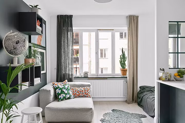 Phòng khách nhỏ với ghế sofa và sàn gỗ tạo ra một không gian hài hòa, nhẹ nhàng làm ấm không gian.