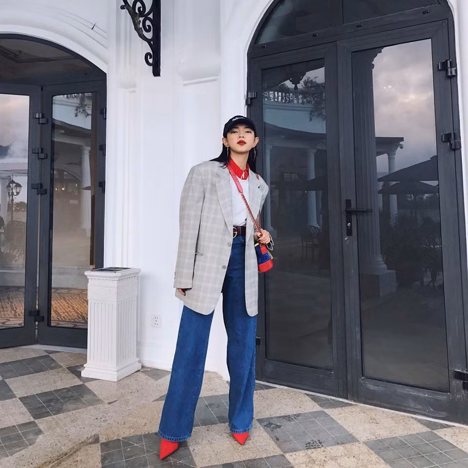 Châu Bùi luôn chứng tỏ sức hút của một "IT Girl" thời trang, khi luôn mang đến những set đồ độc đáo. Người đẹp lựa chọn mẫu áo blazer kẻ ô độn vai làm điểm nhấn trên bộ trang phục cá tính. Cô khéo léo đồng điệu màu sắc giữa áo thun cùng túi xách Gabrielle của Chanel và mẫu giày boots đỏ nổi bật.