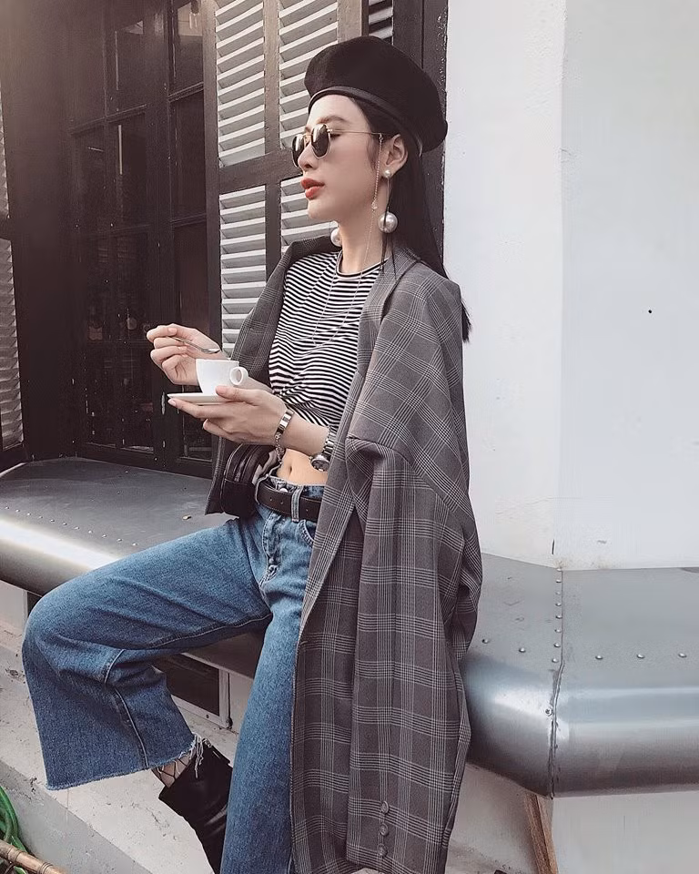 Trong năm 2017, mẫu áo khoác kẻ ô sắc xám chiếm lĩnh tủ đồ của dàn sao Việt mỗi khi xuất hiện trên phố. Angela Phương Trinh tinh tế khi kết hợp cùng áo thun kẻ sọc buộc vạt, quần jeans ống loe và boots cao cổ sành điệu.