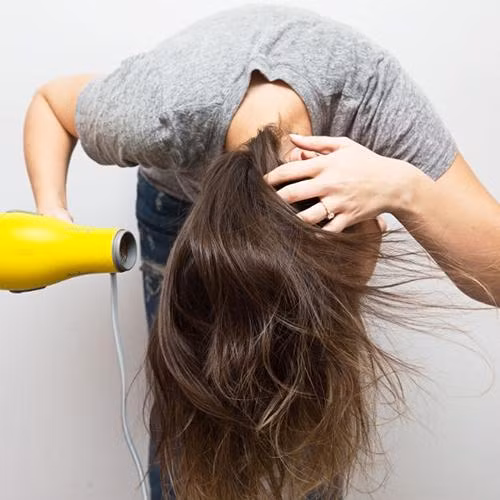 3. Cúi đầu khi sấy tóc Vừa giúp mái tóc sau khi sấy trông dày và mượt hơn, nó còn giúp mái tóc dễ đi vào nếp, vào kiểu không kém gì ngoài salon. Bởi vậy, thay vì đứng sấy tóc như bình thường các bạn hãy cúi gập người xuống rồi sấy tóc.
