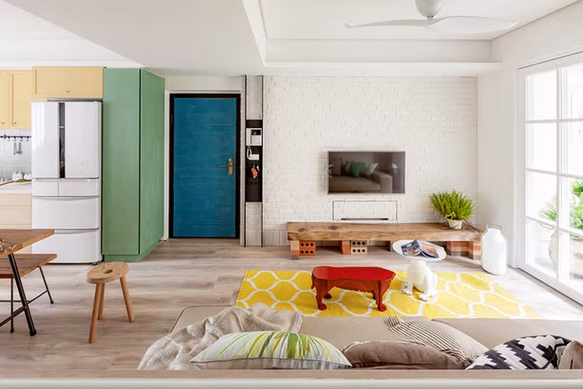 Màu trắng chủ đạo tạo cảm giác thoáng rộng, giá sách, thảm và ghế cùng một số vật trang trí khác có màu nổi bật trở thành điểm nhấn cho căn phòng.