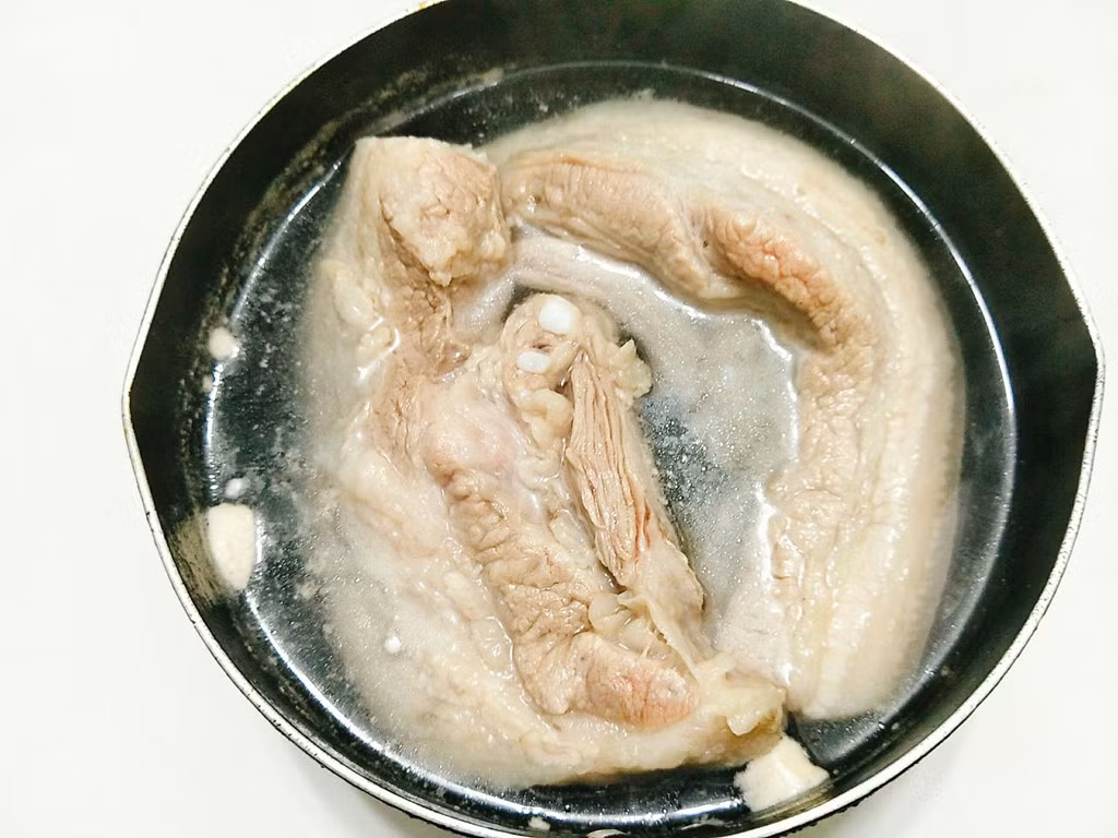 Hướng dẫn cách làm: Thịt ba chỉ bạn cạo sạch phần bì, rửa lại thật sạch. Đổ nước vào nồi đun sôi rồi bạn cho một chút muối vào nồi, tiếp theo bạn cho thịt ba chỉ vào luộc sơ qua khoảng 2 phút xong vớt ra đĩa để cho nguội bớt.