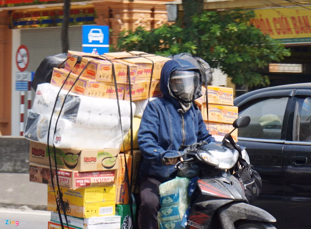 Người chở hàng đi xe máy bịt kín mặt khi phải chạy ngoài đường dưới thời tiết khắc nghiệt.