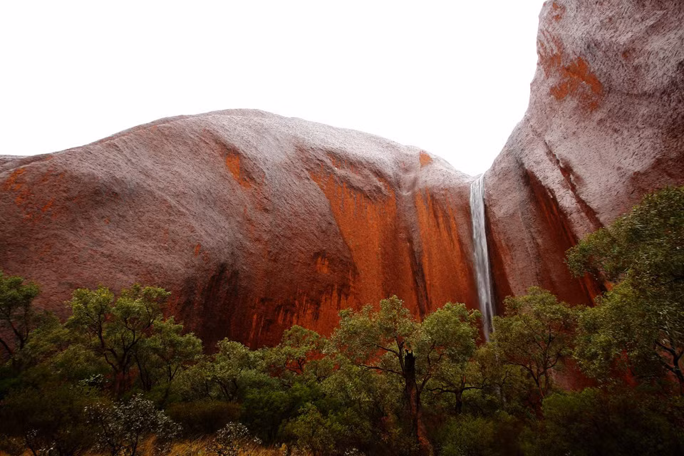 Một dòng thác đổ xuống từ đỉnh Uluru. Nhiều báo cáo cho thấy du khách tới tham quan Uluru đã có cách cư xử không phù hợp như làm ô nhiễm nguồn nước, phá hoạt các tranh vẽ cổ, vi phạm các quy tắc an toàn. "Ngọn núi là một nơi rất linh thiêng, không phải là sân chơi như công viên giải trí hay Disneyland. Chúng tôi hoan nghênh khách du lịch. Chúng tôi không đóng cửa du lịch, chỉ dừng hoạt động leo núi", Wilson nói. Ảnh: Getty.