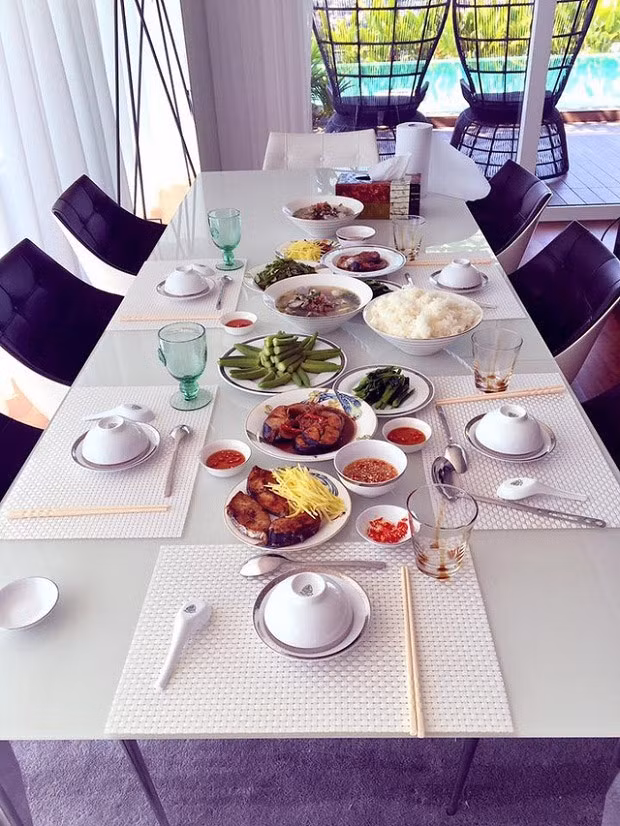 Khu bếp hiện đại, ấm cúng với bộ bàn ăn trắng - đen sang trọng. Từ bếp có thể nhìn thông ra bể bơi.