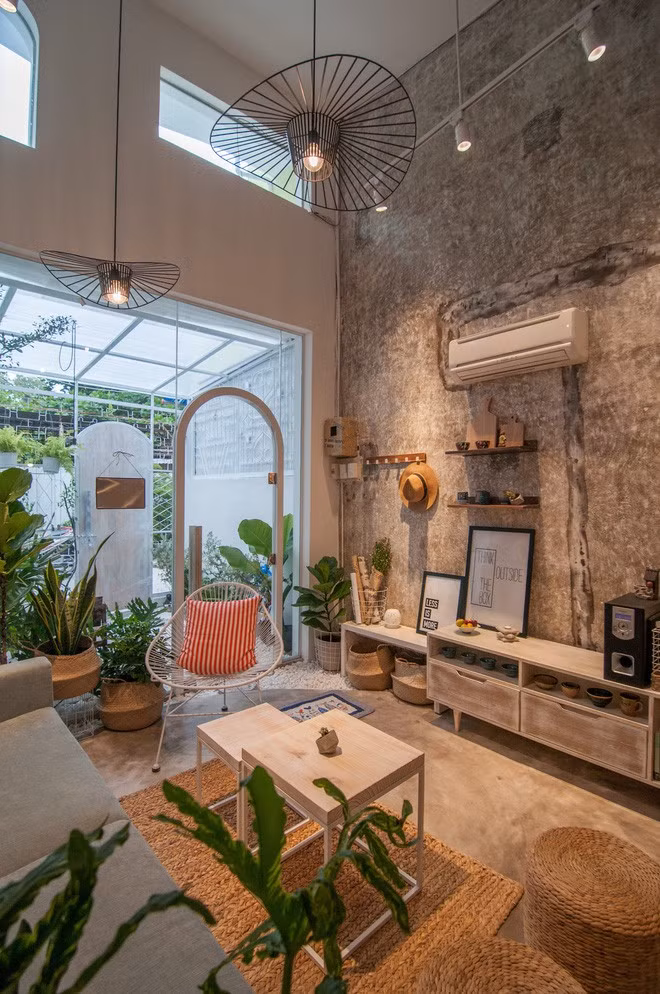 Thay cho tường và cửa sắt kéo trước đây là hệ cửa kính lớn ở phòng khách nhìn ra ngoài vườn, nhờ đó diện tích trong nhà như được nới rộng thêm. (Ảnh: Nguyễn Thanh Nhân)
