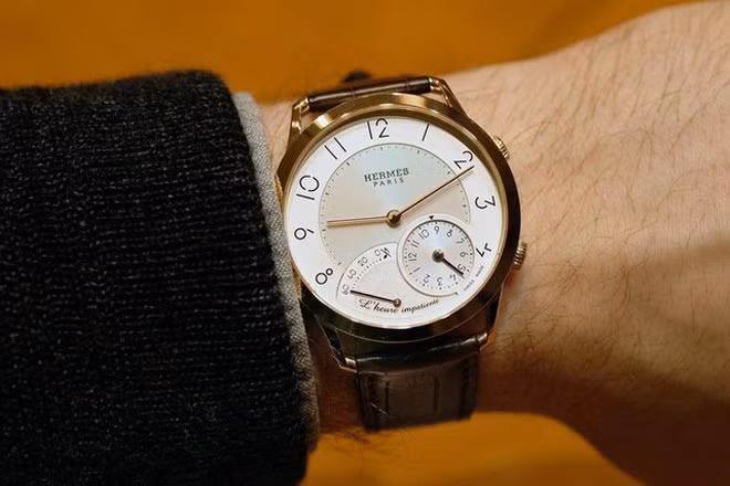 Chiếc đồng hồ bằng vàng hồng nguyên khối giá 53.000 USD - Slim d'Hermés L'heure Impatiente được thiết kế bởi nghệ nhân nổi tiếng Jean-Marc Wiederrecht. Khi đến giờ, chiếc đồng hồ sẽ đánh 1 tiếng chuông thật tinh tế, nhẹ nhàng.