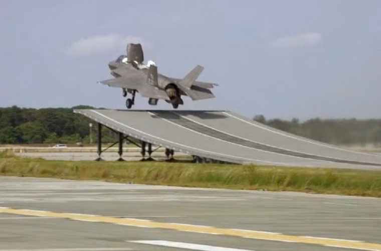 Khoảng khắc tiêm kích tàng hình F-35B cất cánh từ đường băng kiểu nhảy cầu đặt trên mặt đất. Với hệ thống động cơ độc đáo, F-35B chỉ cần đường băng rất ngắn để chạy đà bay lên trong khi khi hạ cánh thì như trực thăng.