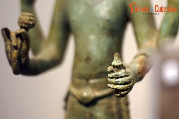 Tượng có bốn tay, hai tay trước cầm nụ sen và bình nước cam lồ. Hai tay sau cầm tràng hạt và quyển sách.