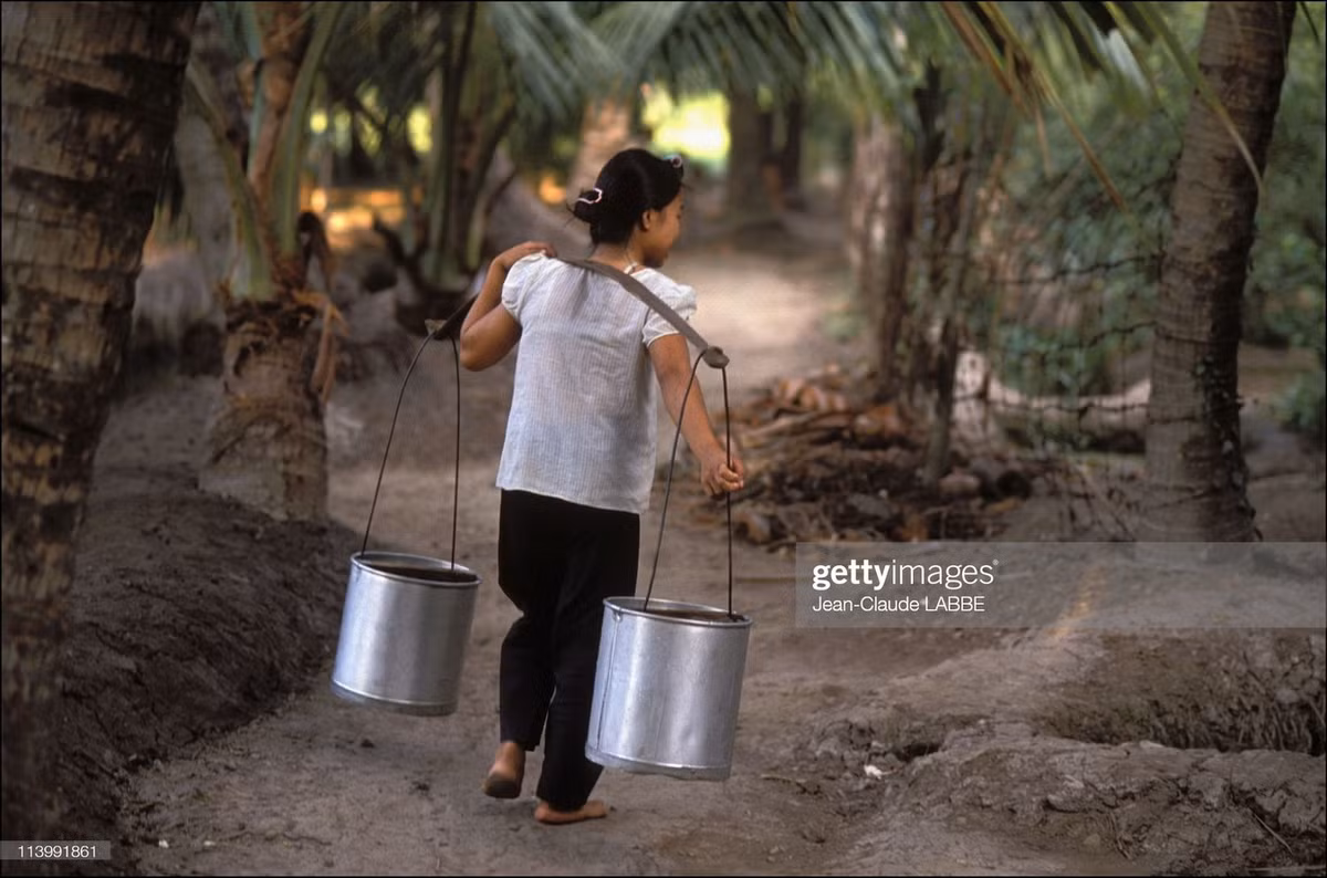 Thôn nữ gánh nước. Năm 1991, nhiều vùng nông thôn ngoại vi TP HCM chưa có nước máy, người dân phải lấy nước từ giếng công cộng để dùng trong sinh hoạt.