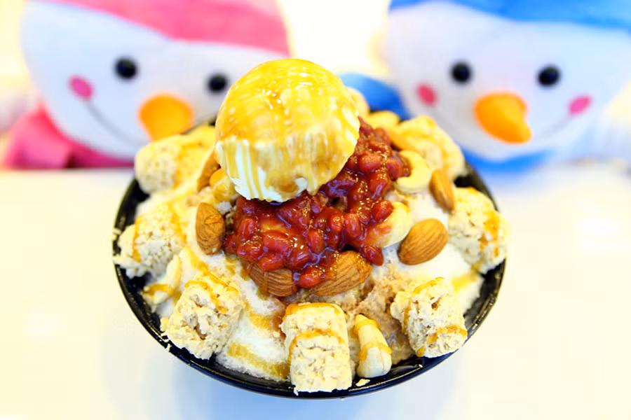 Bingsu là một món tráng miệng đẹp và rất phổ biến ở Hàn Quốc. Nhìn vào Bingsu, bạn sẽ vô cùng “mãn nhãn” với các loại trái cây, nào kem, sữa, kẹo, chocolate, trà xanh, bánh cookie, siro... Tất cả tạo nên một món ăn đầy sắc màu ngọt ngào, bắt mắt, khiến bạn khó mà cầm lòng. Bingsu thường được trình bày trong những thố to, phần bên trên đầy những loại topping kích thích vị giác. Đặc biệt, với những ai thích “sống ảo”, hay chụp hình món ăn thì những món Bingsu lên hình lung linh, rực rỡ chắc chắn sẽ khiến bạn hài lòng.