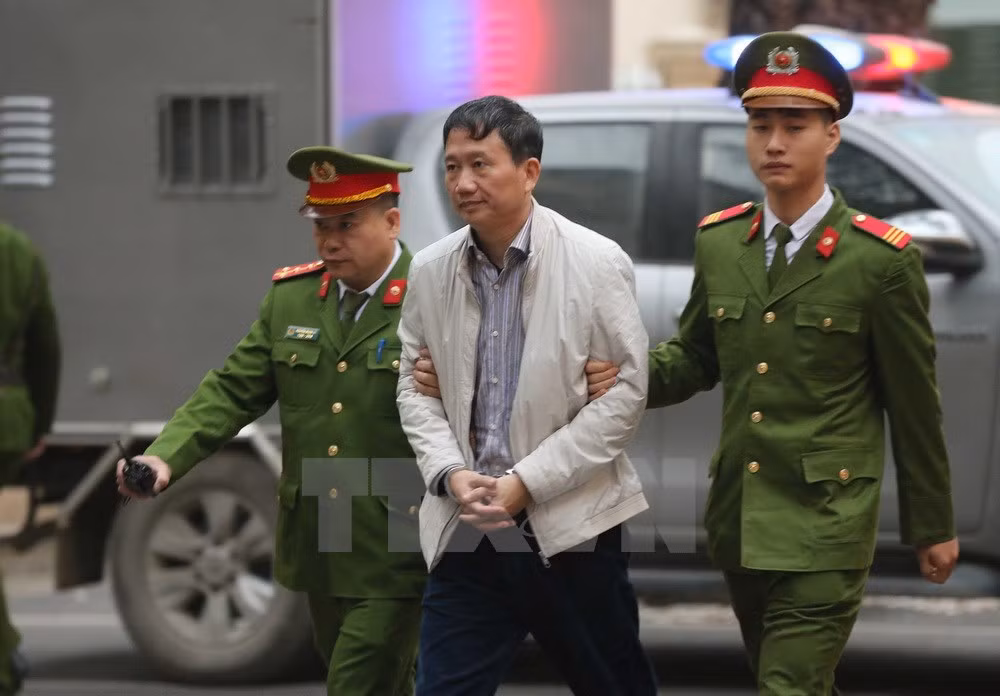 Cảnh sát dẫn giải bị cáo Trịnh Xuân Thanh, nguyên Chủ tịch Hội đồng quản trị, Tổng Giám đốc PVC tới tòa. (Ảnh: Doãn Tấn/TTXVN).