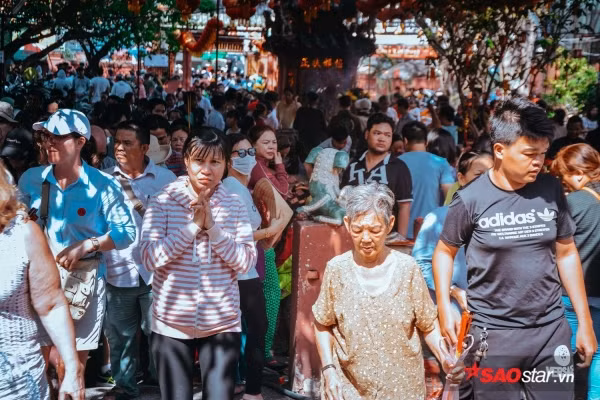 Theo quan niệm dân gian: “Mùng 8 cúng sao, mùng 9 cúng chư thiên (vía Ngọc Hoàng), mùng 10 cúng đất”. Vì vậy, mỗi năm, cứ đến độ mùng 9 âm lịch, người người ở khắp nơi lại kéo nhau về chùa Phước Hải, hay còn gọi là chùa Ngọc Hoàng (Mai Thị Lựu, Q.1, TP. HCM) để thắp hương, khấn vái và cầu may cho một năm mới ấm no, hạnh phúc. Ảnh: Dù giữa trưa nhiệt độ trên 34 độ C, nhiều người vẫn đổ về chùa Ngọc Hoàng để cầu may.