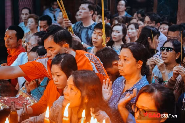 Mọi người đều vật vã mồ hôi vì thời tiết nóng cộng với người đông, đốt nhang và vàng mã bên trong chùa liên tục.