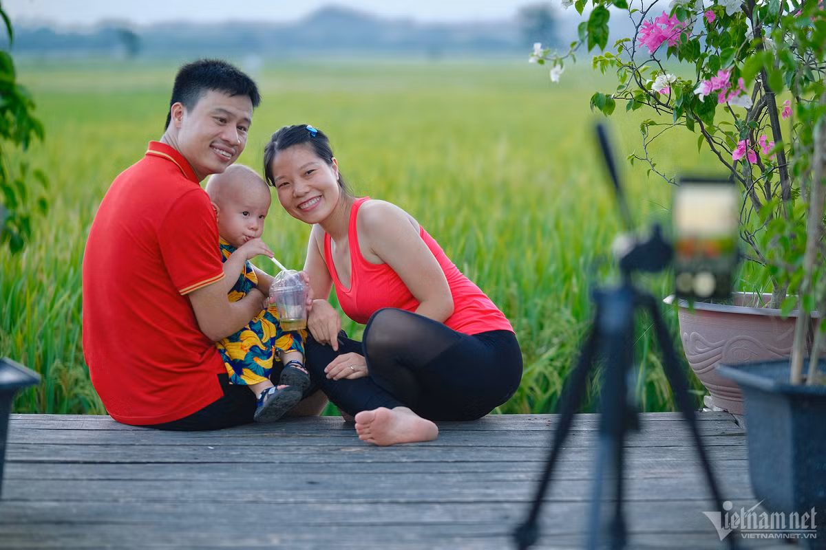 Chị Hảo, anh Quang (ở Phụng Châu, Chương Mỹ) và con trai mang theo chân ba càng để tự chụp ảnh cho cả gia đình. Ảnh: Mạnh Hùng.