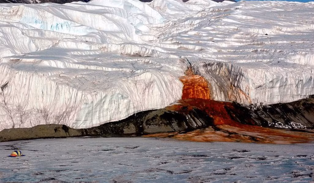Một nhóm các nhà khoa học từ 2 trường đại học của Mỹ, Alaska Fairbanks và Colorado đã tuyên bố giải mã được bí ẩn 'thác máu'. Theo đó, nước từ thác này có chứa nhiều oxit sắt (III) nên sẽ chuyển sang màu đỏ khi sắt trong nước tiếp xúc với không khí. Đó là nguyên nhân khiến nước chảy ra khỏi thác có màu đỏ.