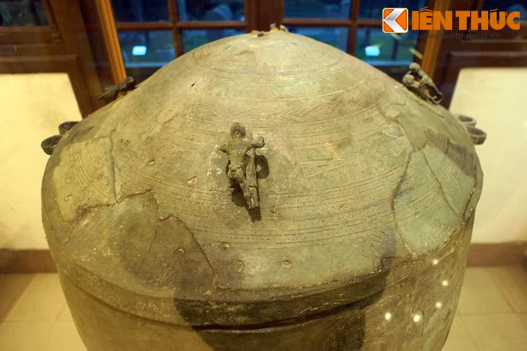 Thạp có dáng hình trụ, thuôn dần xuống đáy. Nắp đậy hình nón cụt, ở giữa có hình mặt trời 12 tia, xung quanh có 11 vành hoa văn.